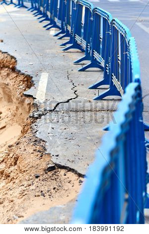 Protective barrier and destroyed asphalt road in the Guardamar del Segura after the storm Costa Blanca. Province of Alicante. Spain