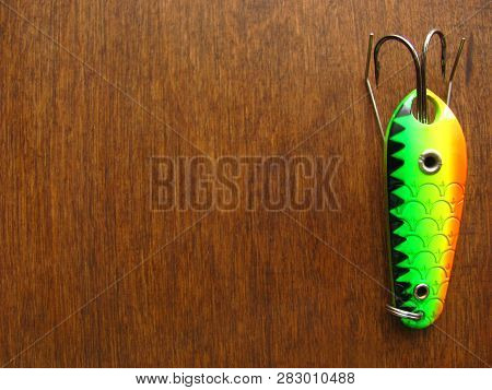 Kramatorsk, Ukraine - 19th March, 2018: One Multicolor Fishing Spinner Lure Upright On A Wooden Back