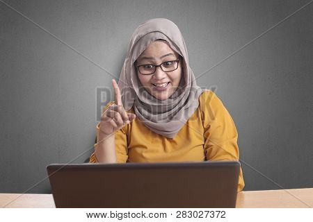 Portrait Of Asian Muslim Businesswoman Working On Laptop At The Office,amiling And Thinking Gesture,
