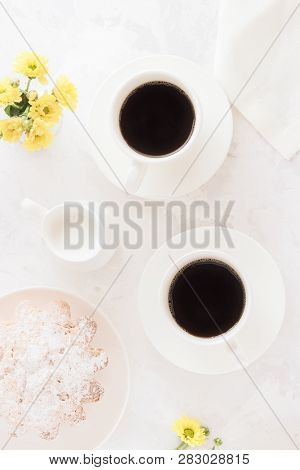 Breakfast On White Table. Two Cups Of Black Coffee Pie And Yellow Flowers. Top View
