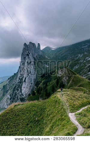 Mountain Landscape In The Swiss Alps With Jagged Peaks And A Pristine Blue Mountain Lake In The Vall
