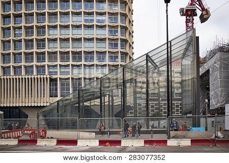 London, Uk - December 22, 2018 Builders At The Colorful Fence Near Tottenham Court Station