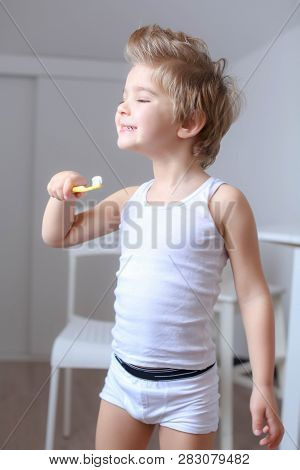 Boy Cleans His Teeth In The Morning And Plays With A Toothbrush.