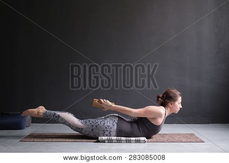 Woman Practicing Yoga, Stretching In Salabhasana Exercise, Double Leg Kicks Pose