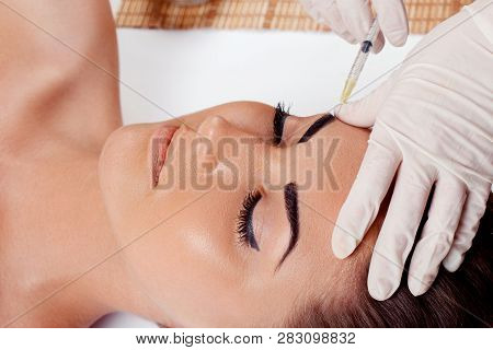 Cosmetology,plastic Surgery,beauty Concept. Beautiful Woman Face And Hand In Glove With Syringe Maki