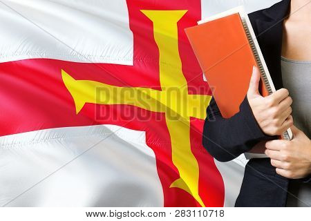 Learning Language Concept. Young Woman Standing With The Guernsey Flag In The Background. Teacher Ho