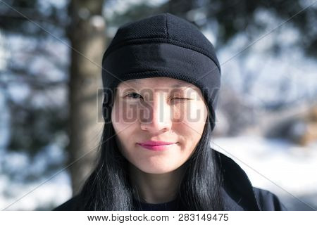 A Chinese Woman Winking At The Camera Outside In Torrington, Connecticut On A Sunny Winter Day.
