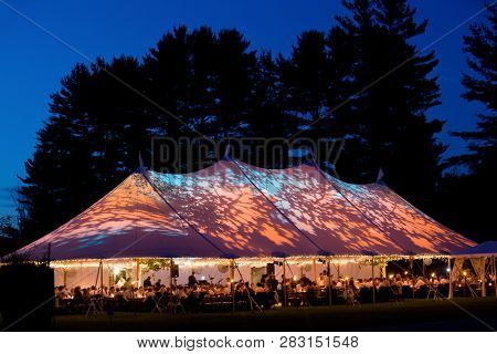 Wedding tent at night - Special event tent lit up from the inside with dark blue night time sky and trees