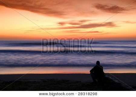 coucher de soleil regardant seul homme à la plage