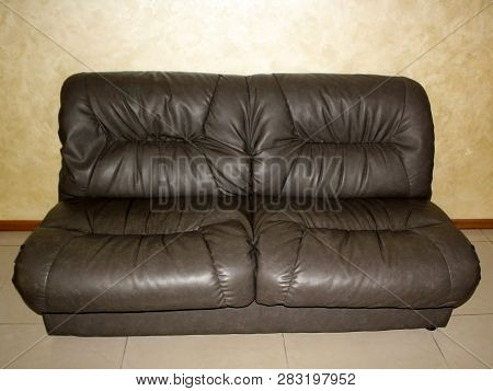 Big Black Leather Sofa Stands Against The Wall