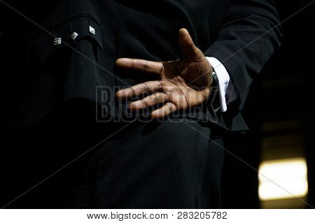 A Black Man In An Elegant Suit Hid His Hand Behind His Back, Not Wanting To Say Hello. Fear Of Commu