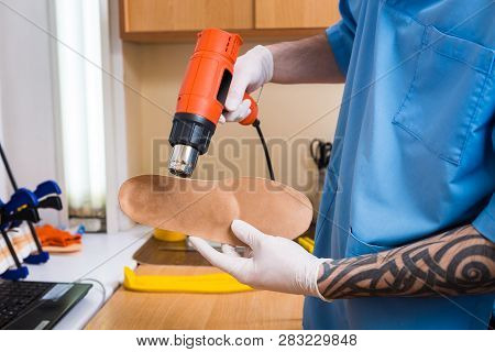 Closeup Hands Of Young Man With Tattoo In Workshop Dressed In Blue Uniform Make Individual Orthopedi