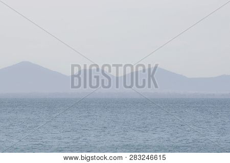 Foggy View Of Mountains Across From The Ocean
