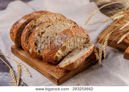 Sliced Craft Bread On A Board Close-up. The Concept Of Healthy Food And Traditional Bakery.