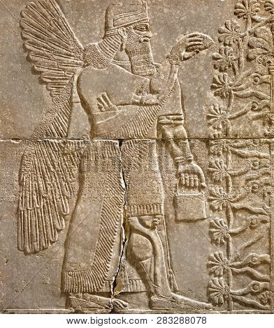 Assyrian Wall Relief Of A Winged Genius With Cuneiform. Ancient Carving Panel From The Middle East H