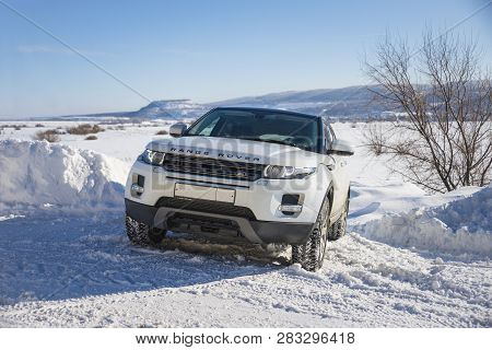 White Range Rover Evoque With A Black Roof On A Winter Road On The Background Of Zhiguli Mountains O