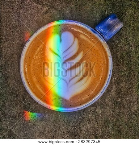 Cappuccino With Latte Art In A Blue Cup With Rainbow. The Drawing On Coffee. Coffee Shop.