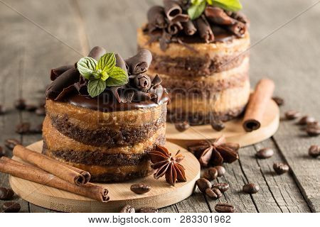 Dark Chocolate Cakes On Black Slattern Board With Mint, Cinnamon, Coffee Beans On A Wooden  Backgrou