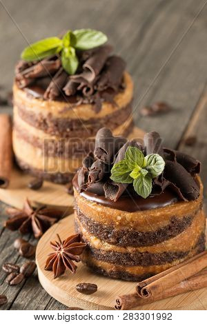Dark Chocolate Cakes On Black Slattern Board With Mint, Cinnamon, Coffee Beans On A Wooden  Backgrou
