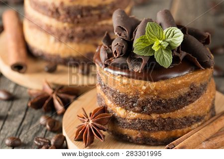 Dark Chocolate Cakes On Black Slattern Board With Mint, Cinnamon, Coffee Beans On A Wooden  Backgrou
