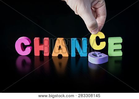 Hand Puts A Letter C Into The Word For Change Concept. Colored Word Chance At Black Background With 