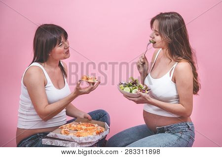 Nutrition Concept, Pregnant Women Eating Pizza On A Pink Background