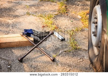 Manual Socket Wheel Wrench And Jack Lying On Ground. Tire Car Repair Objects Concept.