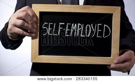 Self-employed Written On Blackboard, Businessman Holding Sign, Business Concept