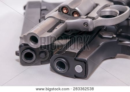 Three Handguns, A 357 Magnum Revolver,, A 9mm Pistol And A40 Caliber Pistol On A White Background