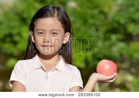 Unemotional Beautiful Filipina Person With An Apple