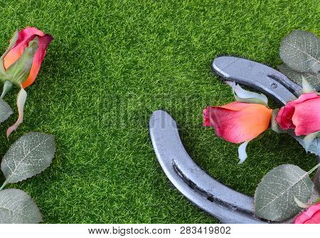 Red Silk Roses, A Horseshoe And Artificial Green Grass For The Running Of The Thoroughbred Race Call
