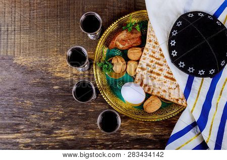 Symbols Of Passover Background Four Glasses Wine And Matzoh Jewish Holiday Bread Over Wooden Board.