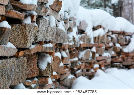 The Fence Is Made Of Granite Stone Under The Snow