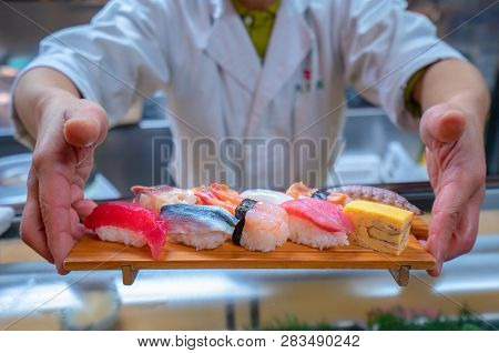 Chef Served Japanese Sushi On Wooded Plate By Hand To Customer, This Immage Can Use For Restaurant, 