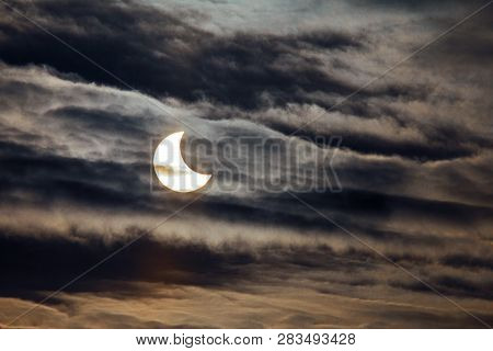 Partial Solar Eclipse On A Dark Background.