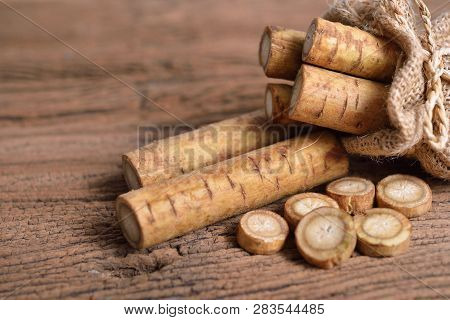 Fresh Burdock Root Or Gobo In Sack And On Wooden Background