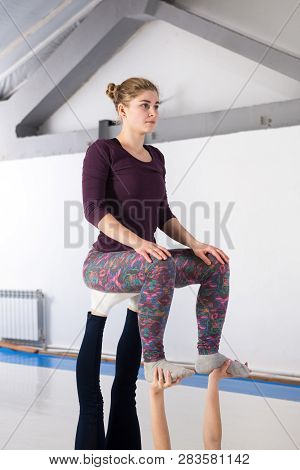 Theme Sports Health Acrobatic Yoga. A Pair Of Two Young Caucasian Girls In The Gym Doing A Base Post