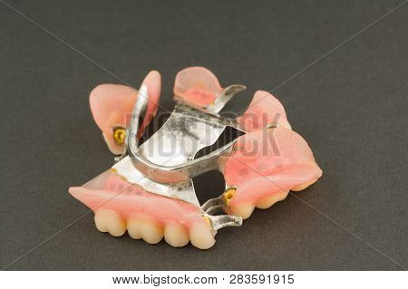 Image Of A Modern Arc  Denture With Attachment On A Black Background