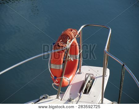 Boat Prow With Orange Lifebelt On The Sea Water . Rescue Concept
