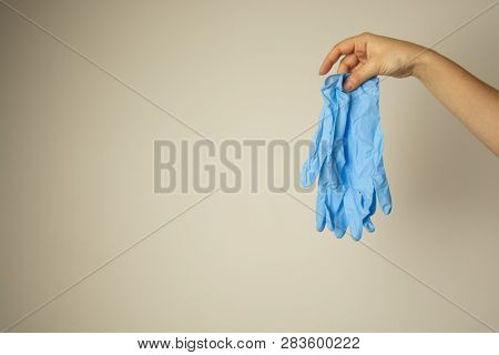 Hands Holding A Prea Of Blue Latex Medical Gloves. Copy Space. Medical, Cosmetology Or Healthy Conce