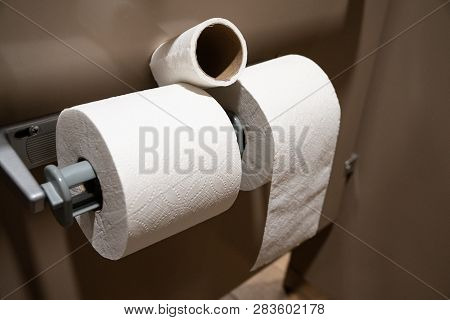 Toliet Paper Rolls Placed On A Toliet Paper Holder Inside Of A Restroom Stall