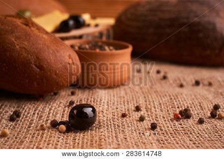 Fresh Bread Baguette With Olive Oil, Olives. Cheese And Rosemary On Wooden Background. Teasty Breakf