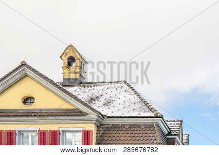 Cozy House With Balcony, Clay Tiled Roof And Gable And Valley Type Of Roof Construction. Building At
