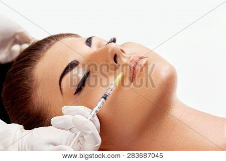 Face Injection. Woman Getting Cosmetic Injection Of Botox In Lips, Closeup. Lip Augmentation. Portra
