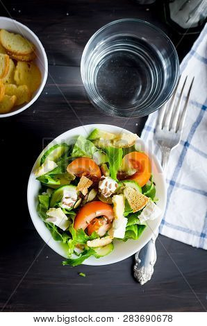 Fresh Light Green Salad With Cucumber, Lettuce, Avocado, Tomatoes, Cheeseand Sseeds And Glass Water 