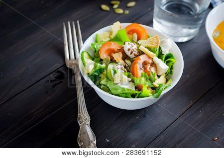 Fresh Light Green Salad With Cucumber, Lettuce, Avocado, Tomatoes, Cheeseand Sseeds And Glass Water 