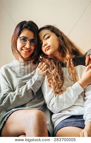 Senior Mom And Her Daughter Are Hugging, Smiling And Dringking A Warm Coffee In Some Morning.