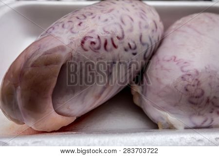 A Pair Of Bull Testicles On A White Plastic Tray. The Outer Surface Of Shell Bull Testicles.