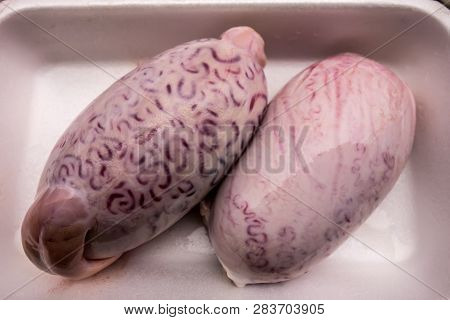A Pair Of Bull Testicles On A White Plastic Tray. The Outer Surface Of Shell Bull Testicles.