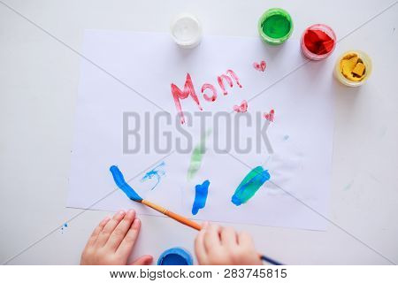 Easter Eggs On White Wooden Background. Flowers And Candies Around.